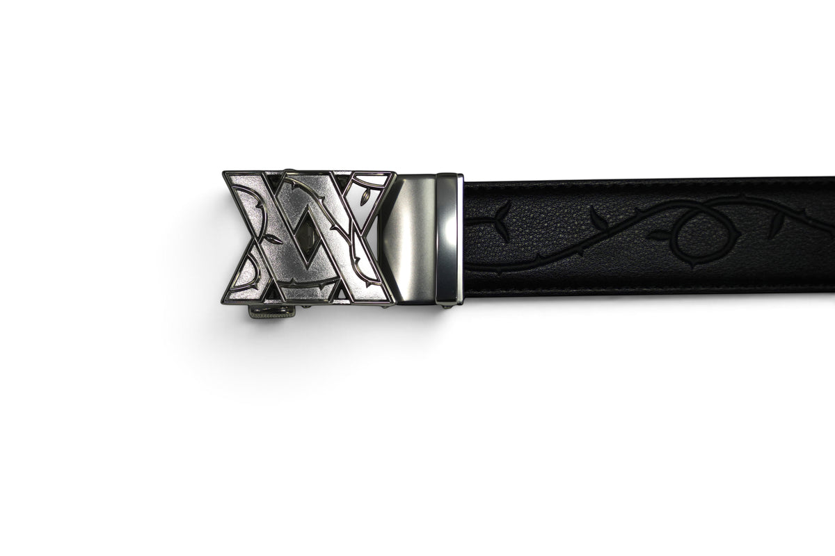 VASANA black leather belt featuring an engraved rose vine pattern and a silver automatic ratchet buckle